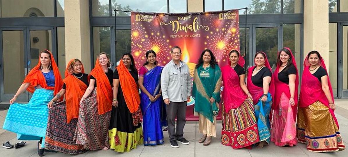 people lined up in front of Diwali backdrop